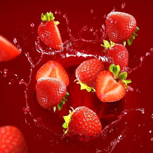 Strawberry falling into the juice with huge splashes